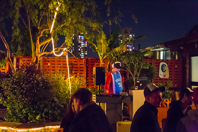 A DJ in the rooftop garden at night