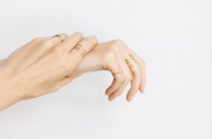 Two hands with fine rings on multiple fingers